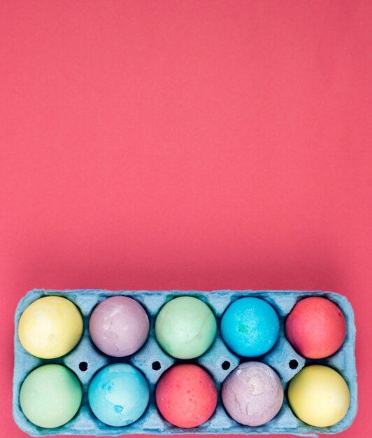 Colourful Easter eggs in box on table 