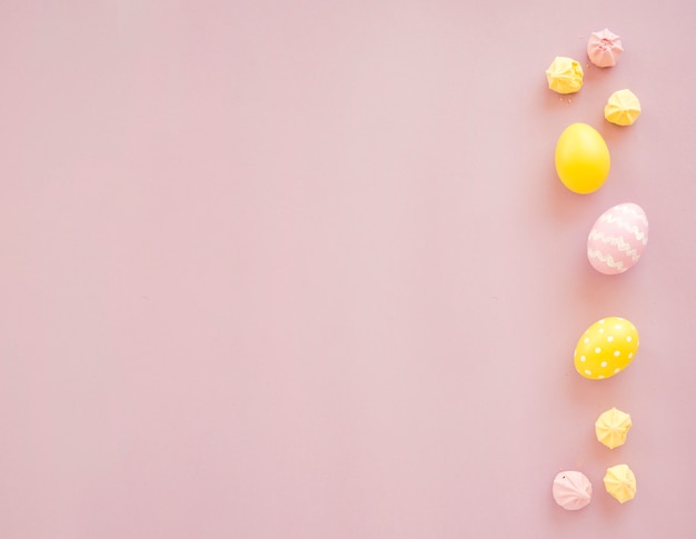 Colourful Easter eggs with sweets on table