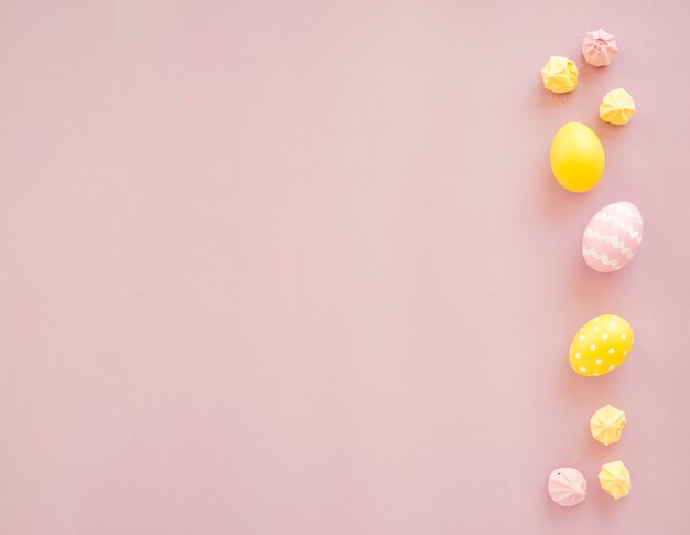 Colourful Easter eggs with sweets on table