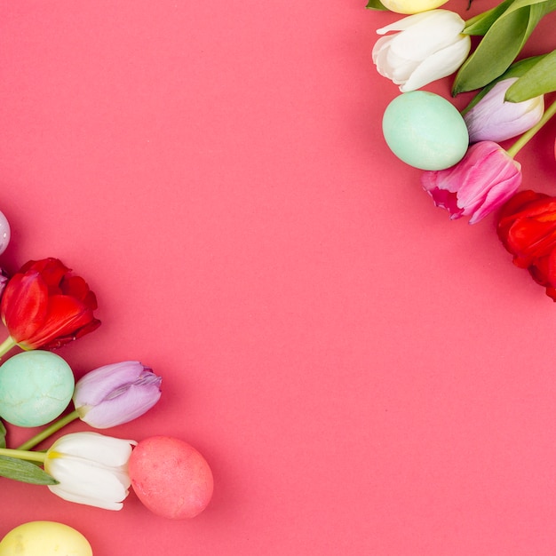 Colourful Easter eggs with tulip flowers on table