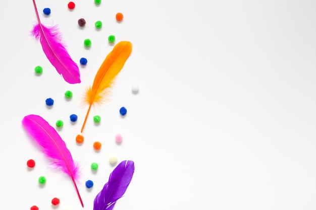 Colourful feathers and cotton balls copy space