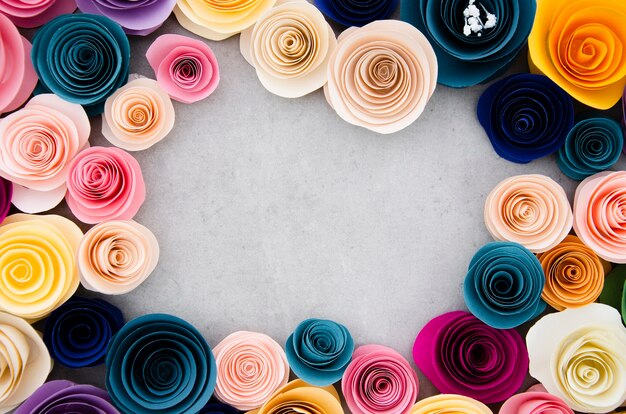 Colourful frame with paper flowers on cement background