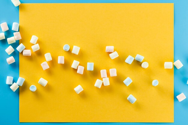 Colourful marshmallow on yellow paper background