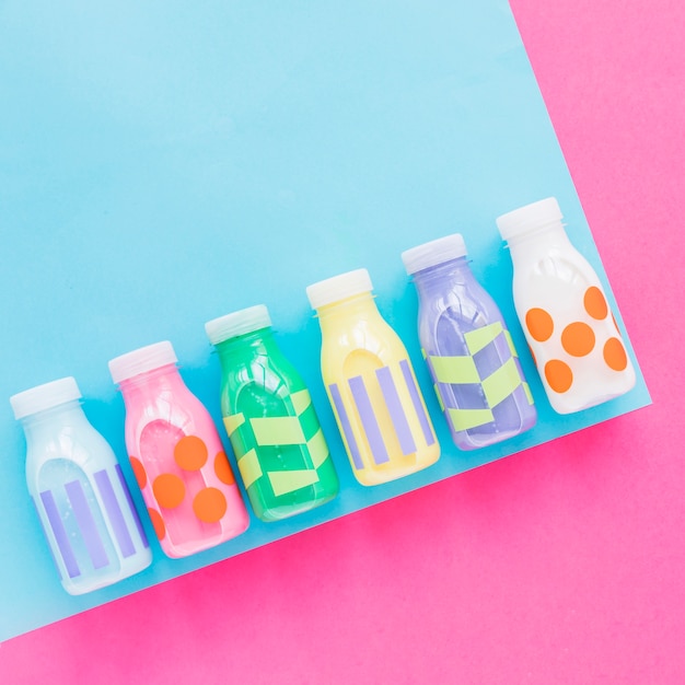 Colourful milk bottles on bright table