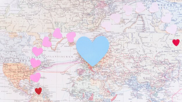 Colourful paper hearts on world map