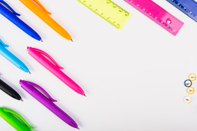 Colourful pens and rulers lie diagonally 