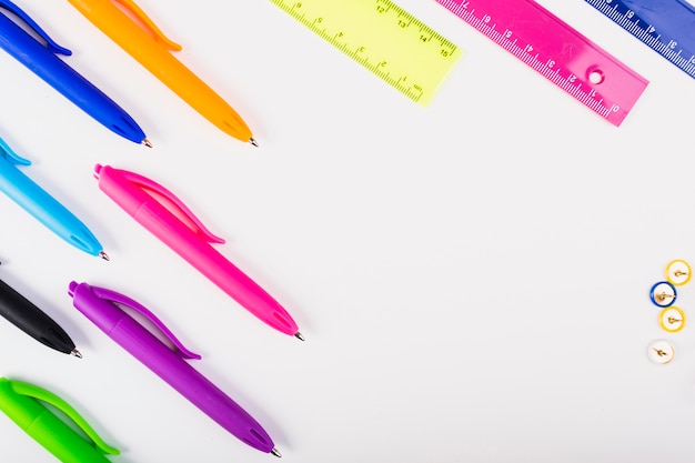 Colourful pens and rulers lie diagonally 