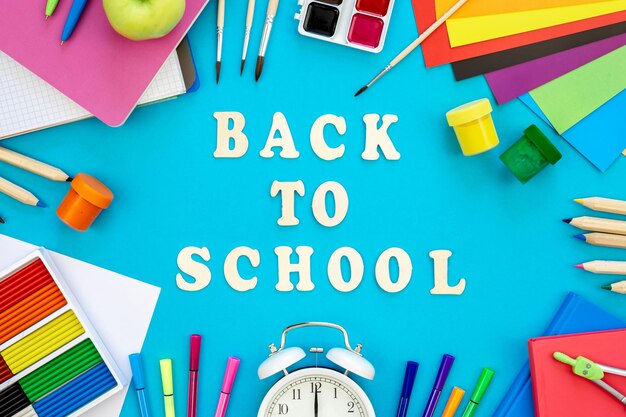 colourful school supplies on a blue background back to school concept