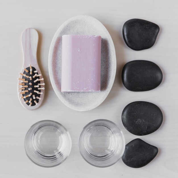 Free photo comb and soap near pebbles