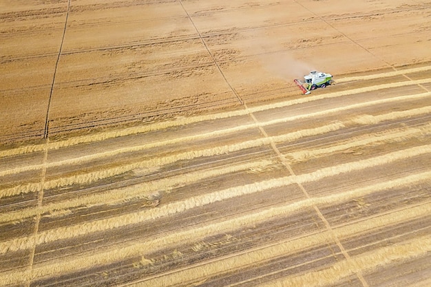 麦畑で作業するコンバイン。コンバインの空中写真。
