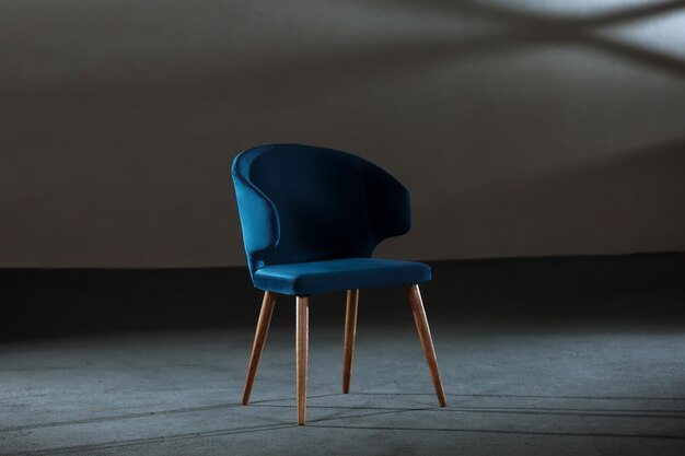 Comfy blue wing chair in a studio with gray walls