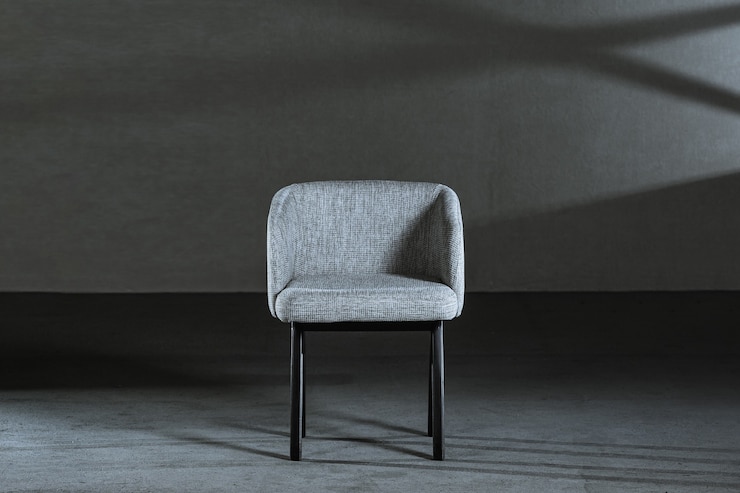 Free Photo comfy white wing chair in a room with gray wall