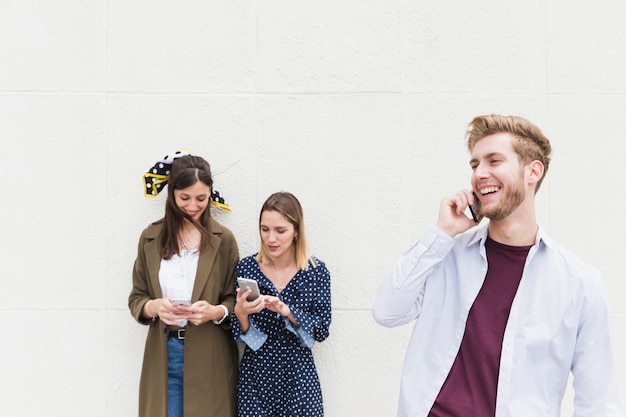 Commuters using mobile phone in front of wall