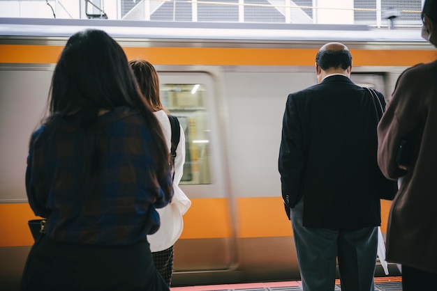 Free photo commuters waiting for the strain to stop at the station