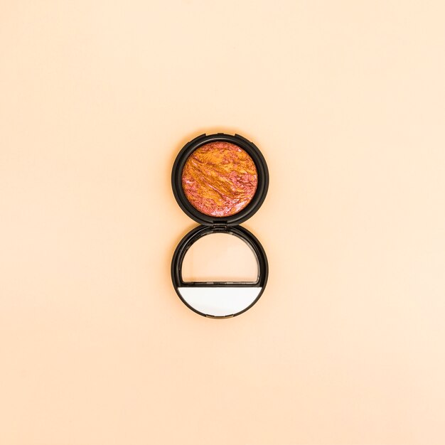 Compact face powder on beige background