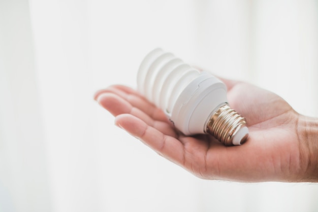 Compact fluorescent light bulb in hand