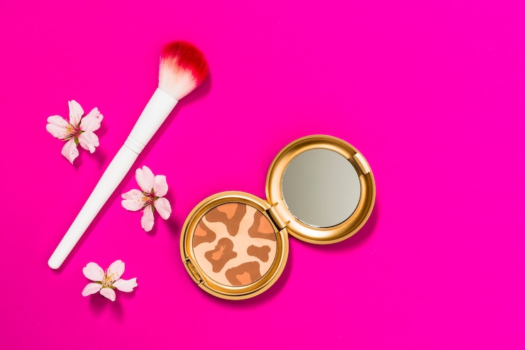 Free Photo compact powder palette with makeup brush and flowers on pink background