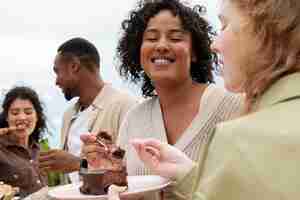 Free photo companions eating outdoors cake and barbeque during party