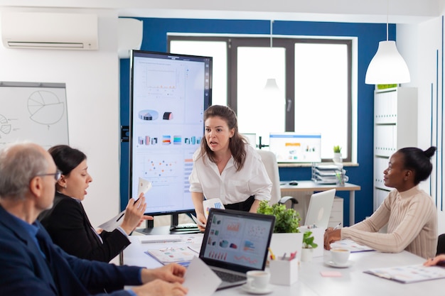 Company boss screaming at senior employee during meeting with in conference room