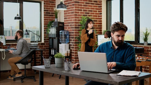 Company employee working on business report with laptop, networking research information and data to plan presentation. Office worker sending email with project charts and graphs.