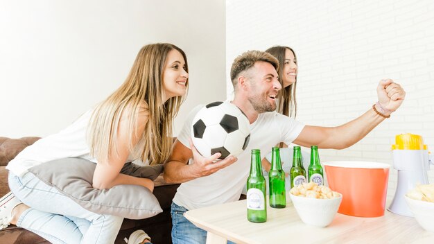 Company of friends rejoicing watching football on tv 