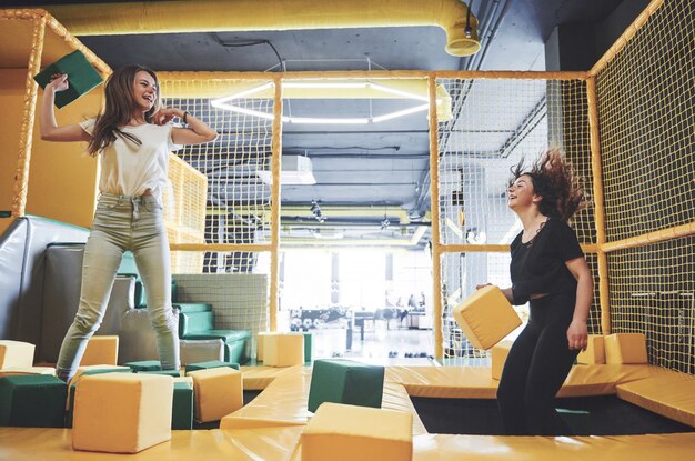 The company is a young woman who has fun with soft blocks on a children's playground in a trampoline center.