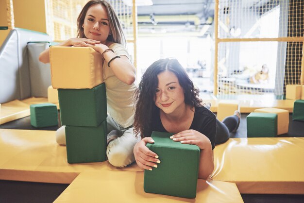 The company is a young woman who has fun with soft blocks on a children's playground in a trampoline center.