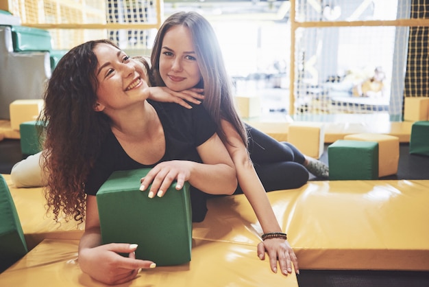 The company is a young woman who has fun with soft blocks on a children's playground in a trampoline center.