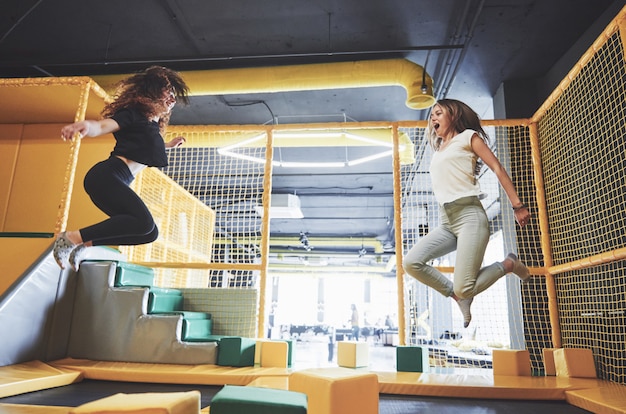 The company is a young woman who has fun with soft blocks on a children's playground in a trampoline center.