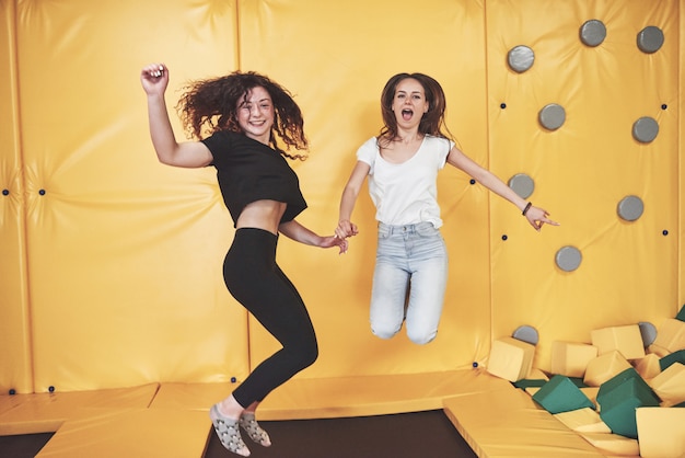 Free photo the company is a young woman who has fun with soft blocks on a children's playground in a trampoline center.