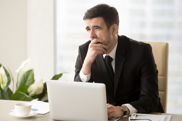 Company manager feeling sleepy at workplace