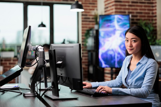 회사 사무실의 자신감 있는 전문 작업자는 컴퓨터 바탕 화면을 사용하여 작업 공간에 앉아 그래픽을 만듭니다. 책상에 앉아 디지털 프로젝트를 개발 중인 크리에이티브 에이전시 직원.