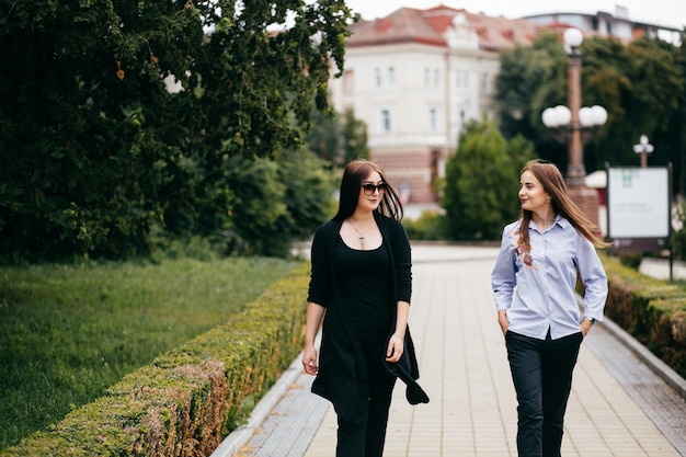 Foto gratuita compagnia di giovani amici con smartphone che camminano in città