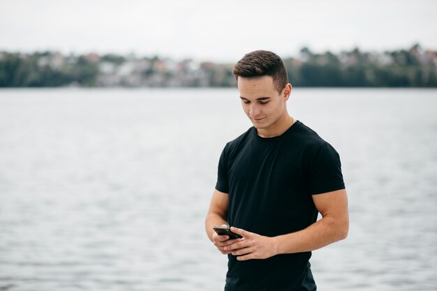 company of young friends with smartphones walking in city