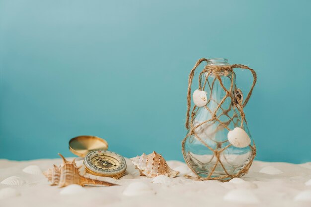 Compass and bottle on the sand