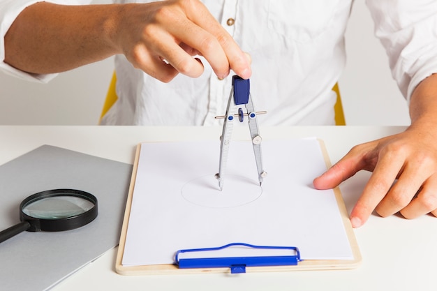 Compass, clipboard and loupe