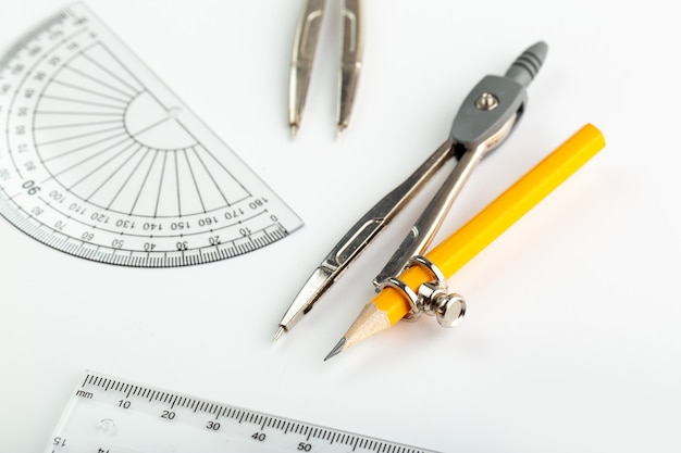 Compass and other drawing figures isolated on white desk