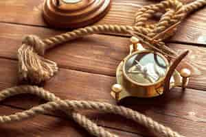 Free photo compass and rope on wooden table close up