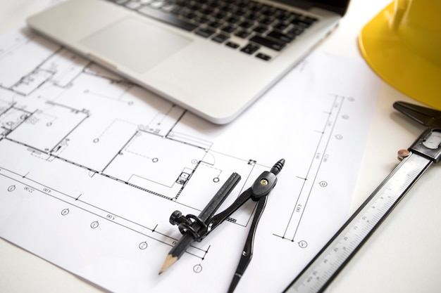 Compasses near laptop and plan