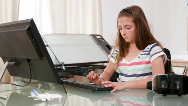 コンピューターのキーボードを使用してオンラインスペースシューターチャンピオンシップ中にビデオゲームを楽しんでいる競争力のある小さな子供。若いマルチプレイヤーストリーミングデジタルチャンピオンシップ。デジタル活動の概念