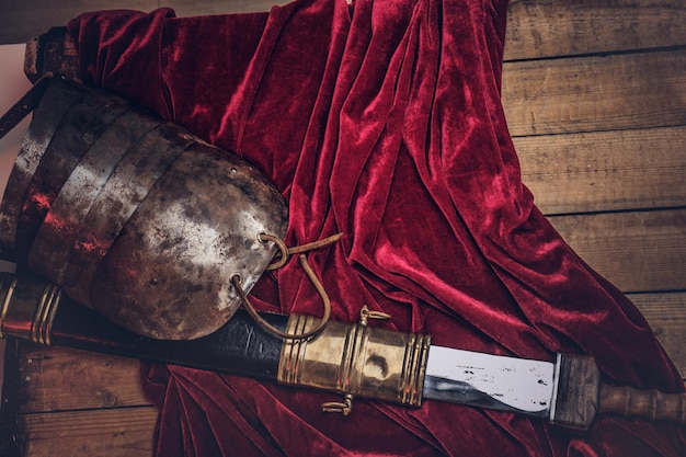 Complete combat equipment of the ancient Greek warrior on a wooden boards background.