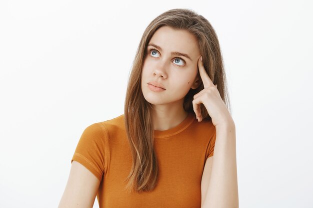 Complicated, beautiful girl looking thoughtful up, thinking, making decision