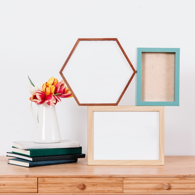 Composed photo frames and flowers on table