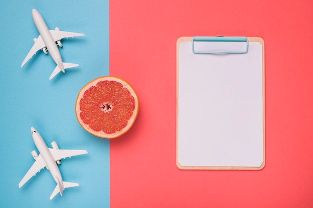 Composition of airplanes grapefruit and white sketch board