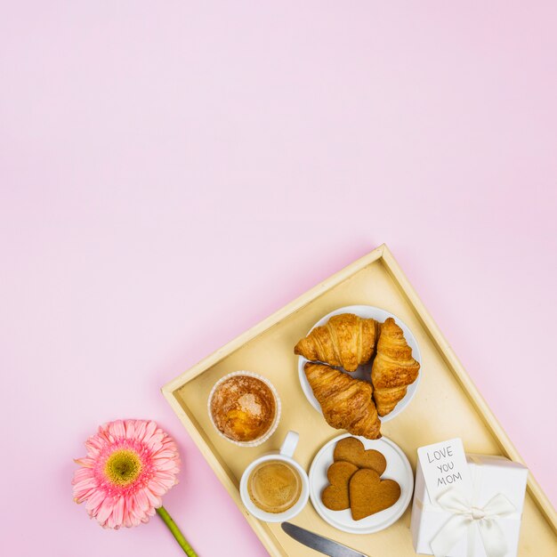 Free photo composition of bakery, cup and present with tag on tray near flower