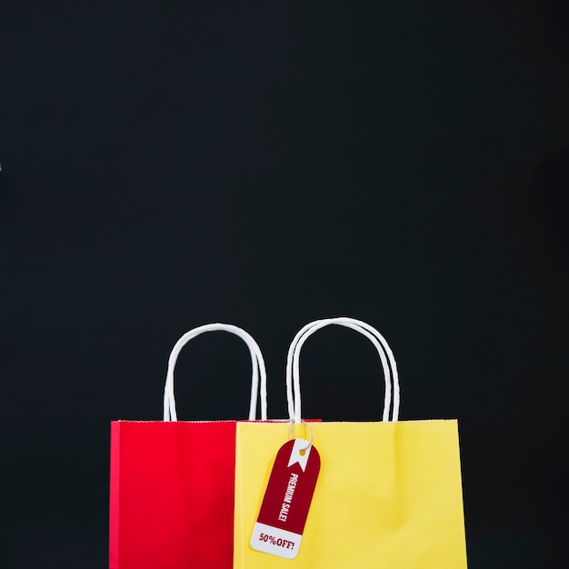 Foto gratuita composizione per il venerdì nero con borsa gialla e rossa