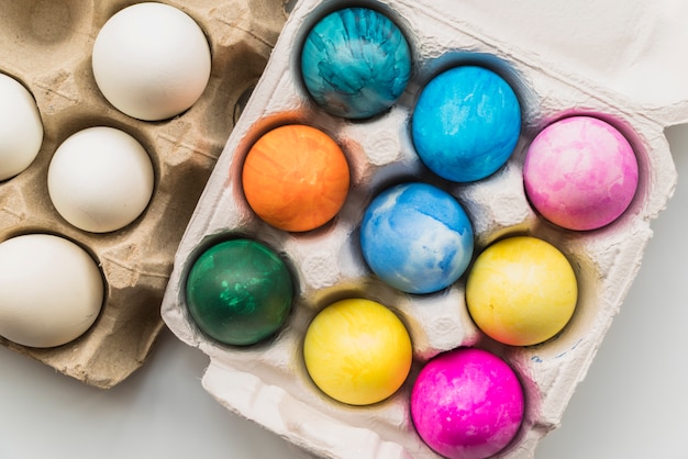 Composition of bright Easter eggs in containers