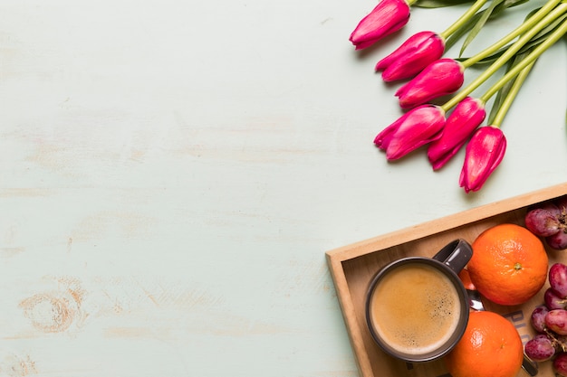 Composition of coffee and fruits with tulips