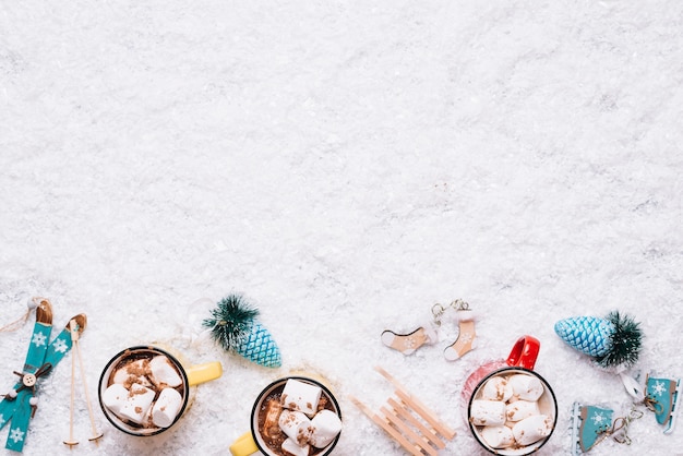 Composition of cups near Christmas toys between snow