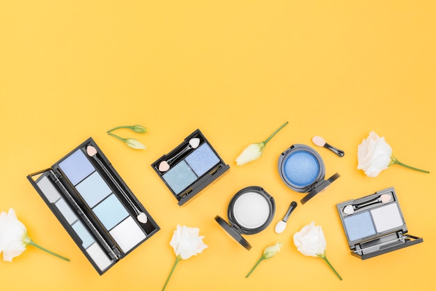 Composition of different cosmetics with copy space on yellow background